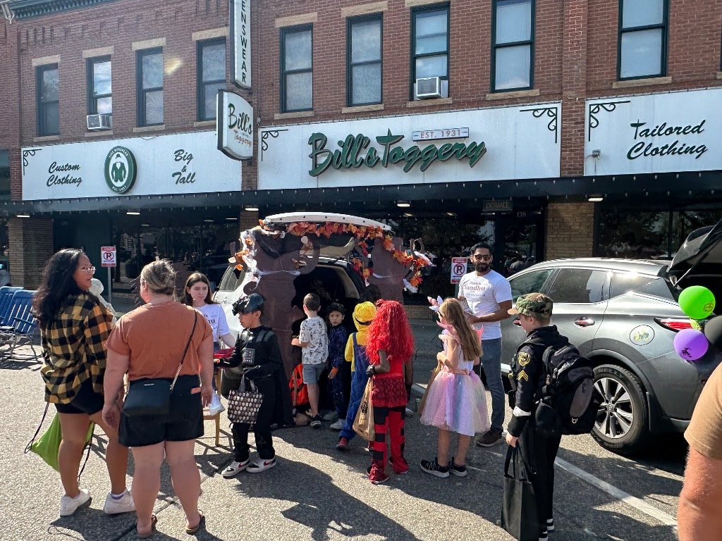 Mustafa Sandhu handing out candy to kids in costumes at the Shakopee Trunk-or-Treat